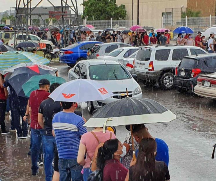 Bajo lluvia, miles de jóvenes esperan vacuna en Hermosillo