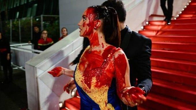Activista se cubre de sangre en la alfombra roja de Cannes